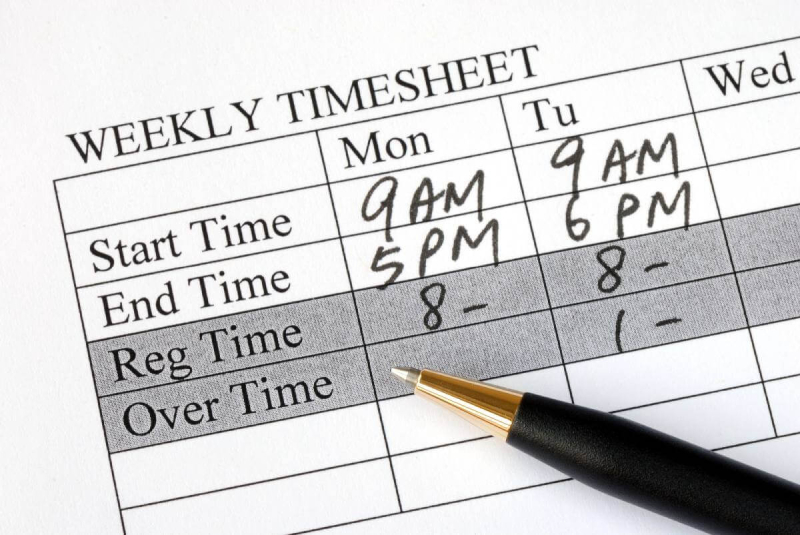 A pen and paper with the words " weekly timesheet ".